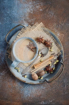 Indian masala chai tea. Spiced tea with milk on dark rusty background.
