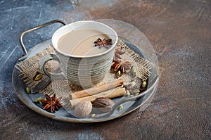 Indian masala chai tea. Spiced tea with milk on dark rusty background.
