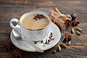 Indian masala chai tea. Spiced tea with milk on the rustic wooden table.