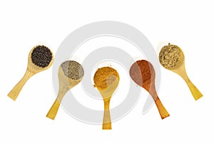 Indian Masala Powders In Wooden Spoon, White Background. Selective Focus