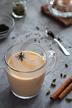 Indian masala tea with spices on a gray background