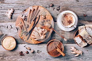 Indian masala tea with spices. Tea with milk, cloves, ginger, cardamom, cinnamon, anise, vanile, honey, nutmeg on wooden