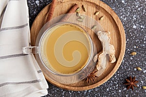 Indian masala tea. Traditional Indian hot drink with milk and spices on a wooden background close-up