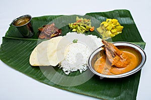 Indian meal with curry shrimp and plain rice on banana leaf tray