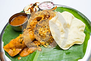 Indian meal with curry squid and fried rice on banana leaf tray