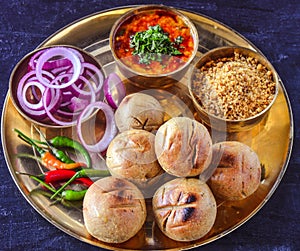 Indian meal-Dal baati churma served in traditional brass plate