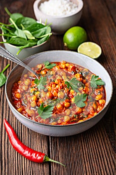 Indian meal, spicy chickpea curry with spinach in a bowl served with rice