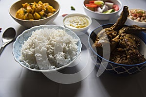 Indian meal steamed rice and chicken curry served with condiments.