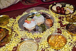 Indian meal (Thali) consisting of fried & boiled rice, different curry, cooked vegetables, fish, cutlet, and sweet stuff