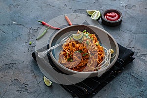 Indian mee goreng, spicy fried noodles in a plate, Singaporean and Malaysian cuisine copy space photo