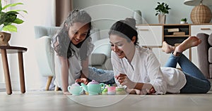 Indian mom and little daughter play tea party at home