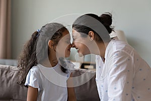 Indian mom and little daughter touch noses express love