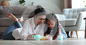 Indian mommy child daughter playing tea party using toy teaset