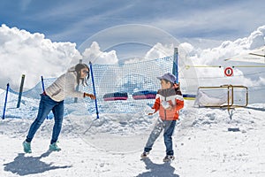 Indian mother and child playing with snow in Zermatt, Switzerland