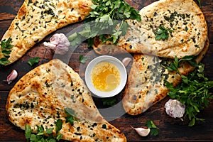 Indian naan bread with garlic butter on wooden table