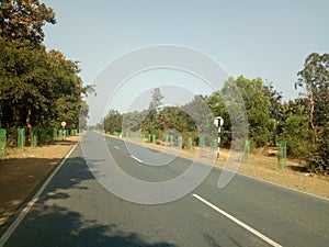 INDIAN NATIONAL HIGHWAY  IMAGE WITH SAL TREES , COCONUT TREE ,BETELNUT PLANT TAMARIND TREE TRIBAL VILLAGE SCENE HOTOS