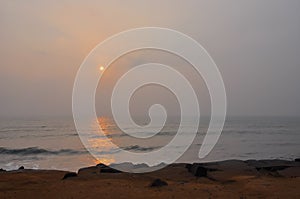 Indian Ocean and sandy shore during sunrise in Pondicherry