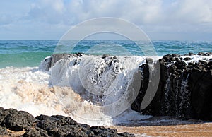 Indian Ocean waves dumping against dark basalt rocks on Ocean Beach Bunbury Western Australia