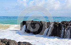 Indian Ocean waves dumping against dark basalt rocks on Ocean Beach Bunbury Western Australia