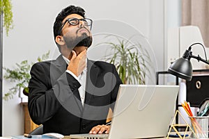 Indian office business man feeling unwell sick ill suffering from sore throat hurt swallowing pain