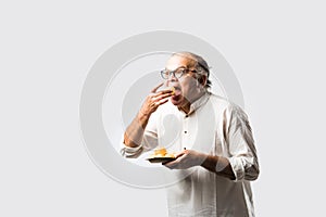 Indian old man eating phuchka, panipuri,  gupchup or golgappa