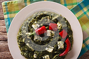 Indian Palak Paneer Spinach with cheese and spices close-up. Horizontal top view