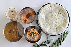 Indian pancakes also known as dosa made with fermented batter of rice and lentils. Served with idli podi chutney, sambar, coconut