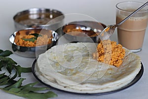Indian pancakes also known as dosa made with fermented batter of rice and lentils. Served with idli podi chutney, sambar, coconut