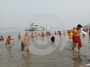 Indian people performing rituals of Makar Sankranti, the Ganges puja or worship in black polluted water