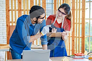 Indian professional male engineer foreman labor worker using laptop computer meeting discussing with cheerful female colleague