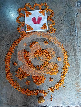 Indian rangoli made by flowers with footprints of a new born baby girl in welcome of her.