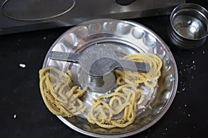 Indian Recipe Murukku, Indian Homemade Recipe Spicy Murukku and Murukku Maker on Top of Silver Plate