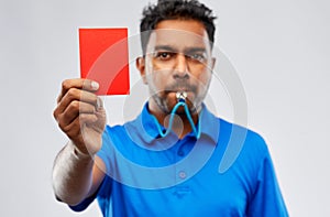Indian referee whistling and showing red card photo