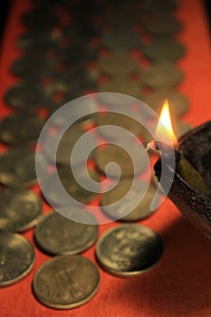 Indian rupee coins with candle light. Stock pile of 1, 2, 5, 10 Indian rupee metal coin currency isolated on red background.