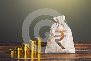 Indian rupee money bag and increasing stacks of coins. Rise in profits, budget fees. Investments. Raise incomes, increase salaries