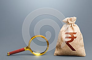 Indian rupee money bag and magnifying glass. Find high-paying job. Most favorable conditions for deposits, loans. Origin