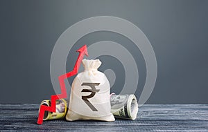 Indian rupee money bag and red arrow up. Influx of investment and capital, increase of wealth. Rising inflation. Economic recovery