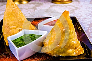 Indian samosas on black plate