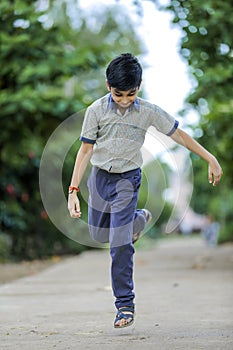 Indian school boy playing hop-scotch in playground