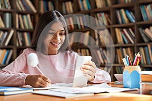 Indian school girl holding phone distance learning using mobile application.