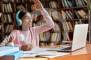 Indian school girl raising hand learning online on video zoom call.