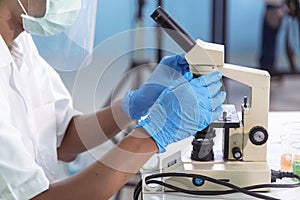 Indian Scientist man look into Microscope research in science laboratory. Asian biochemistry scientist using microscope in