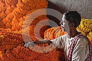 Indian seller with flower garland on Flower market at Mallick Ghat in Kolkata. India