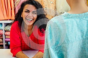 Indian seller women in red kurta stand in her studio showroom