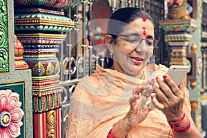 Indian senior woman using mobile phone photo