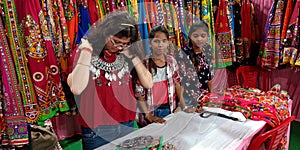 indian shopkeeper girl trying necklace into the store in India