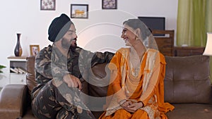 Indian Sikh couple having a nice conversation while sitting on a couch - lifestyle family