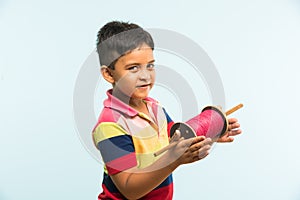 Indian small kid or boy holding spindal or chakri on Makar Sankranti festival, ready to fly Kite