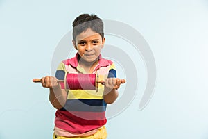 Indian small kid or boy holding spindal or chakri on Makar Sankranti festival, ready to fly Kite