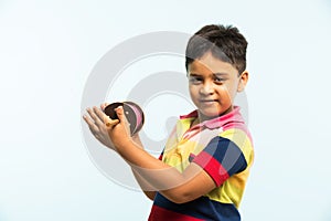 Indian small kid or boy holding spindal or chakri on Makar Sankranti festival, ready to fly Kite